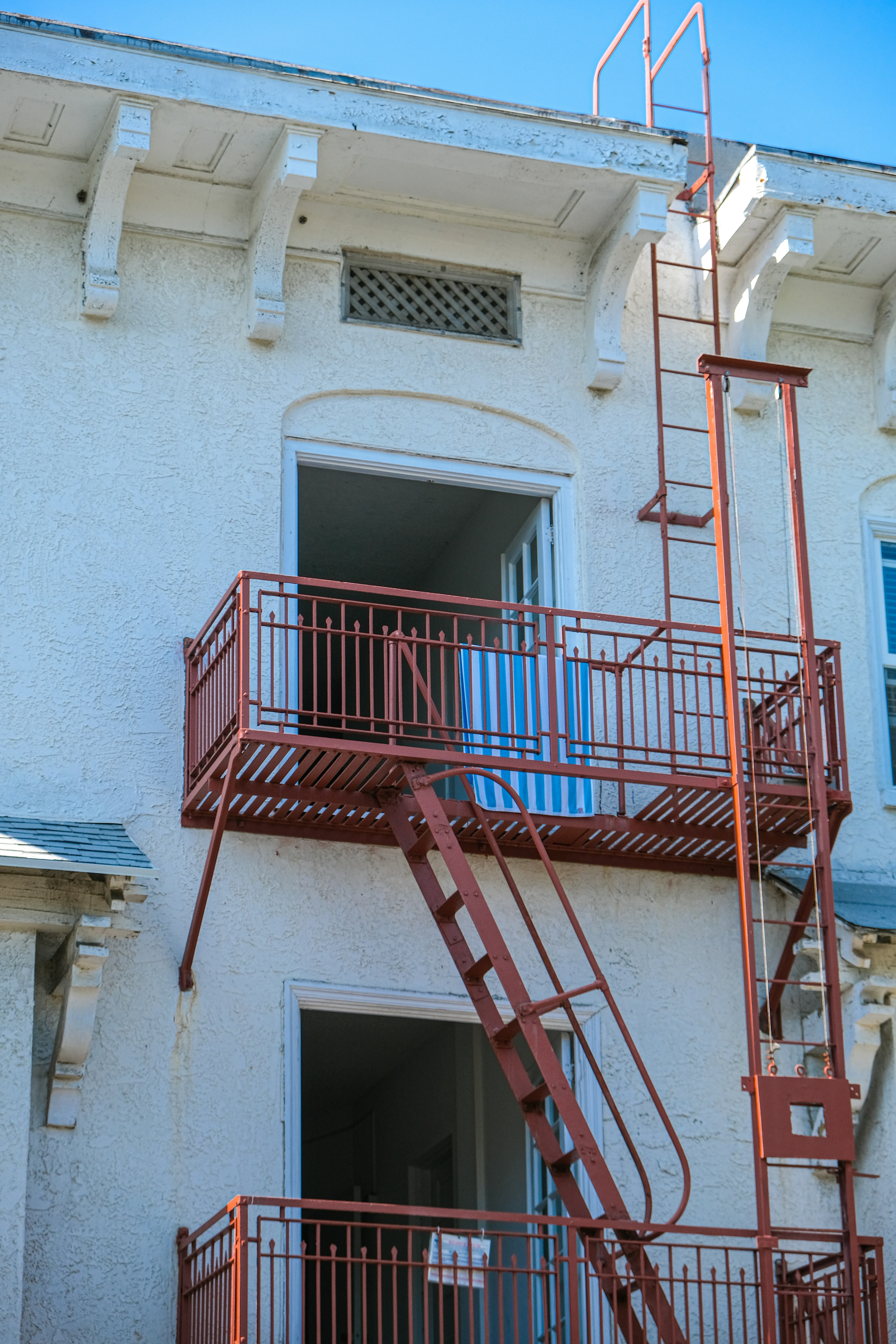 Une échelle d’évacuation rouge à côté d’un bâtiment blanc photo Photo