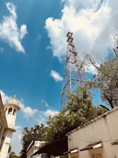 Photo of a telecom tower with traditional Iraqi architecture in the background.