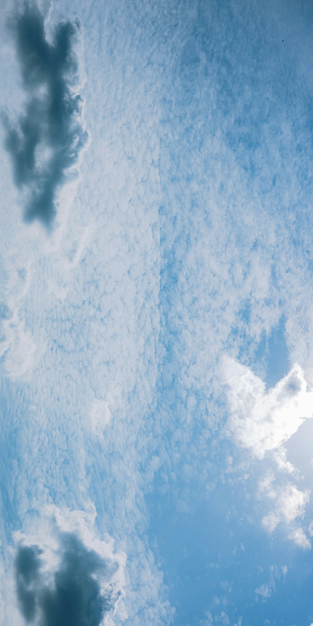 Un avión volando a través de un cielo azul nublado