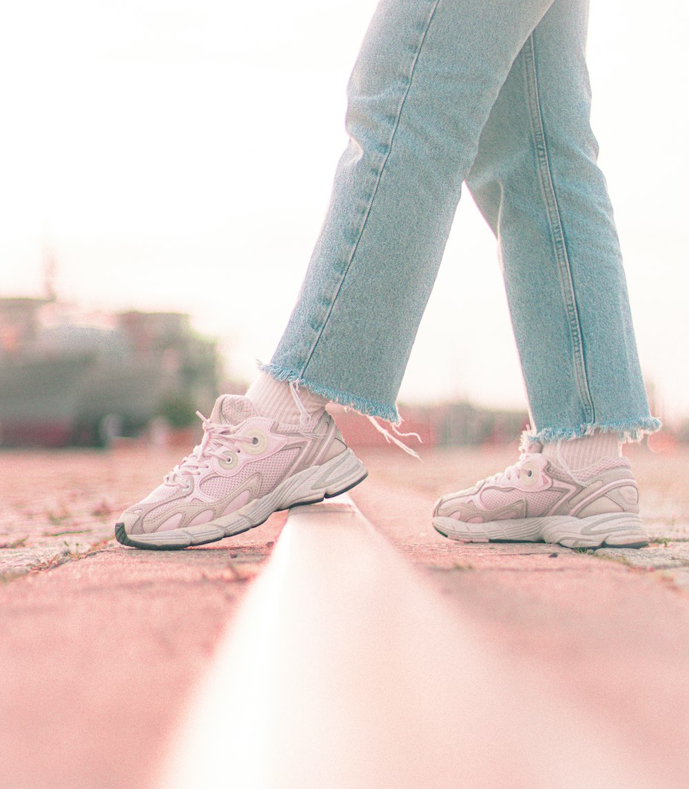 a person standing on a sidewalk with their legs crossed