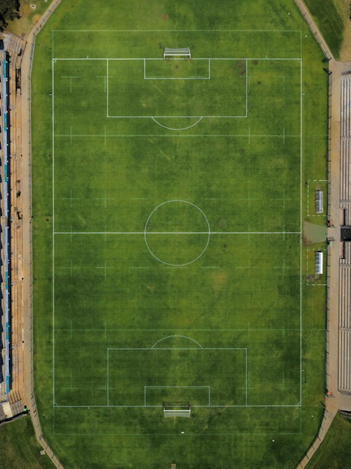 Vue aérienne d’une pelouse de football avec son rond central, ses bancs de touche et ses tribunes : la Celtiis Ligue 1 du Bénin entame sa 4e journée en octobre 2026