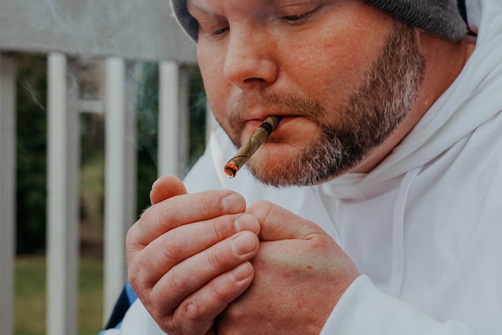 a man in a white robe is smoking a cigarette