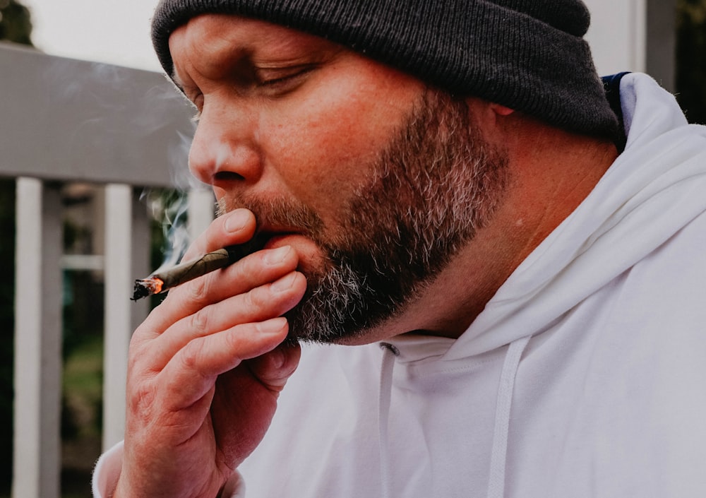 a man with a beard is smoking a cigarette