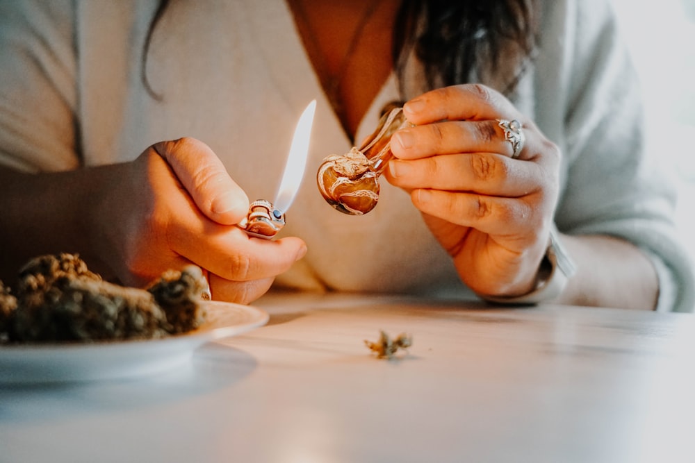 a woman lighting a cigarette on a plate of food