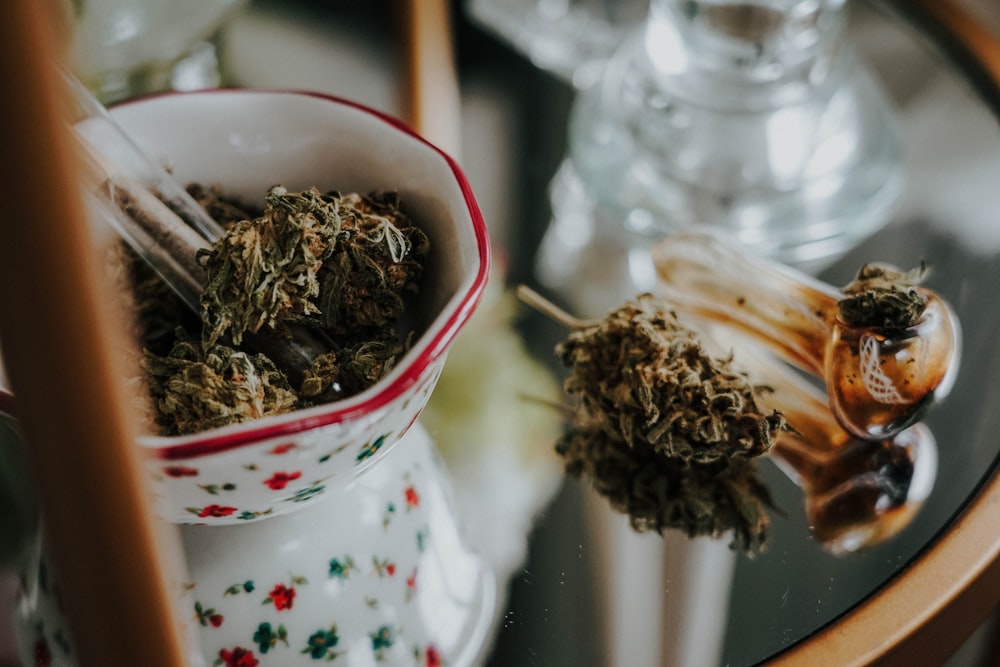 a glass table topped with a cup filled with dried herbs