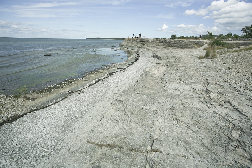 a sandy beach next to a body of water