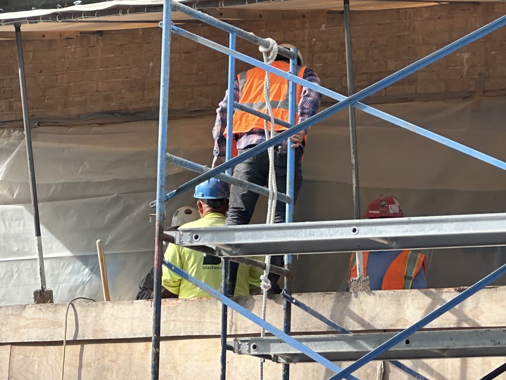 a couple of men standing on top of a scaffolding