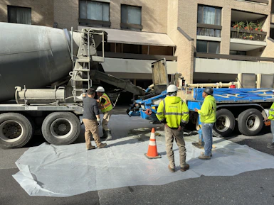 a group of men standing next to a cement truck