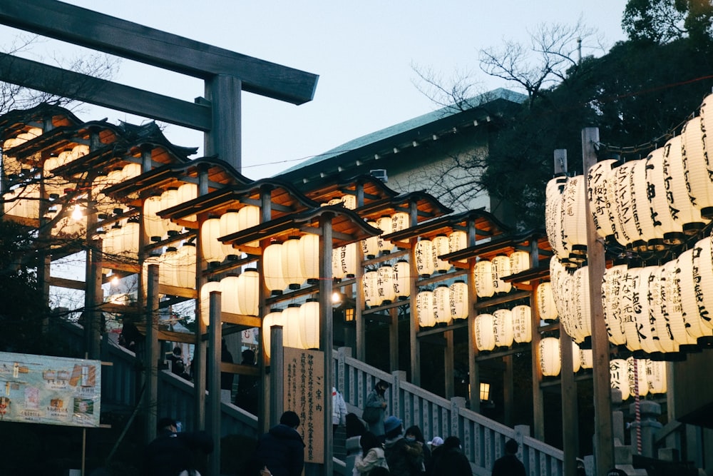 a group of people walking down a street under lanterns