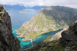 A breathtaking view of the steep cliffs and winding roads of the Cilaos cirque under a bright blue sky.