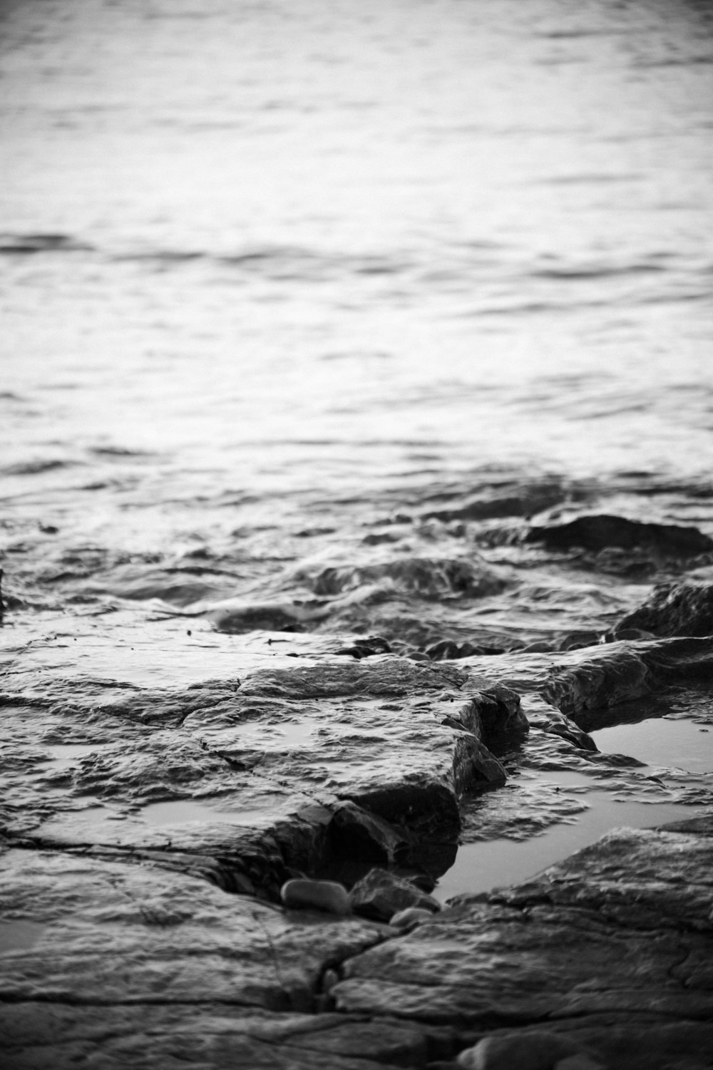 a black and white photo of water and rocks