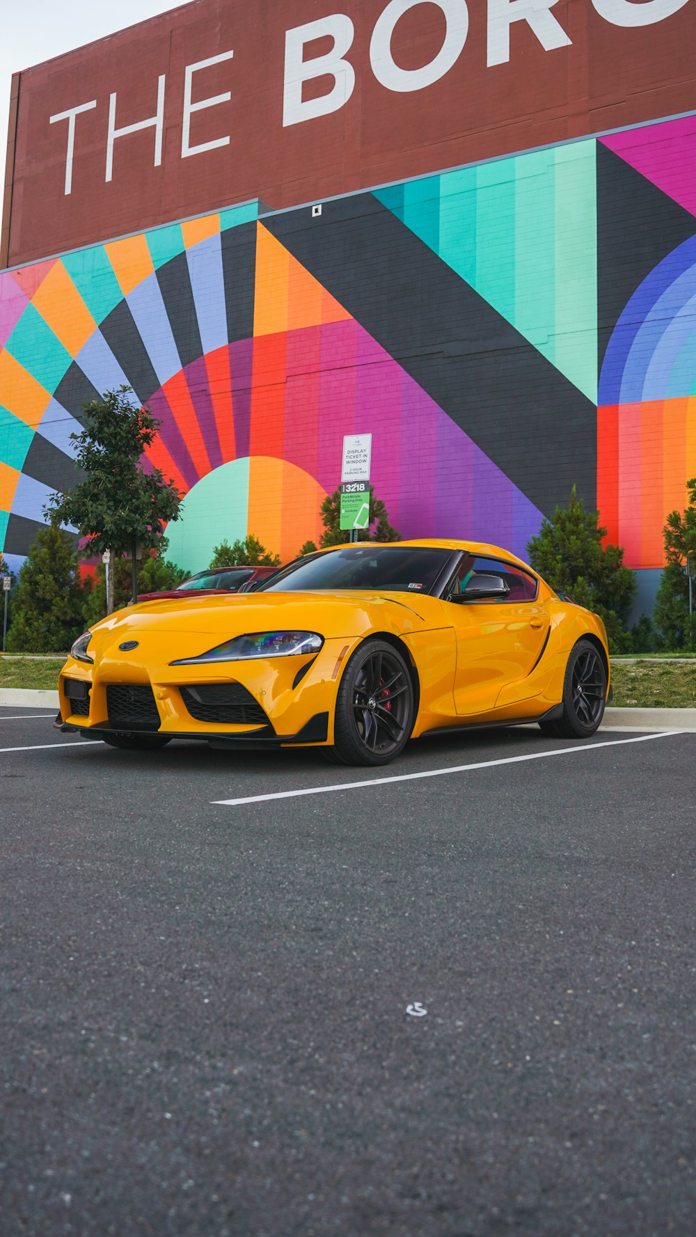 a yellow sports car parked in front of a store
