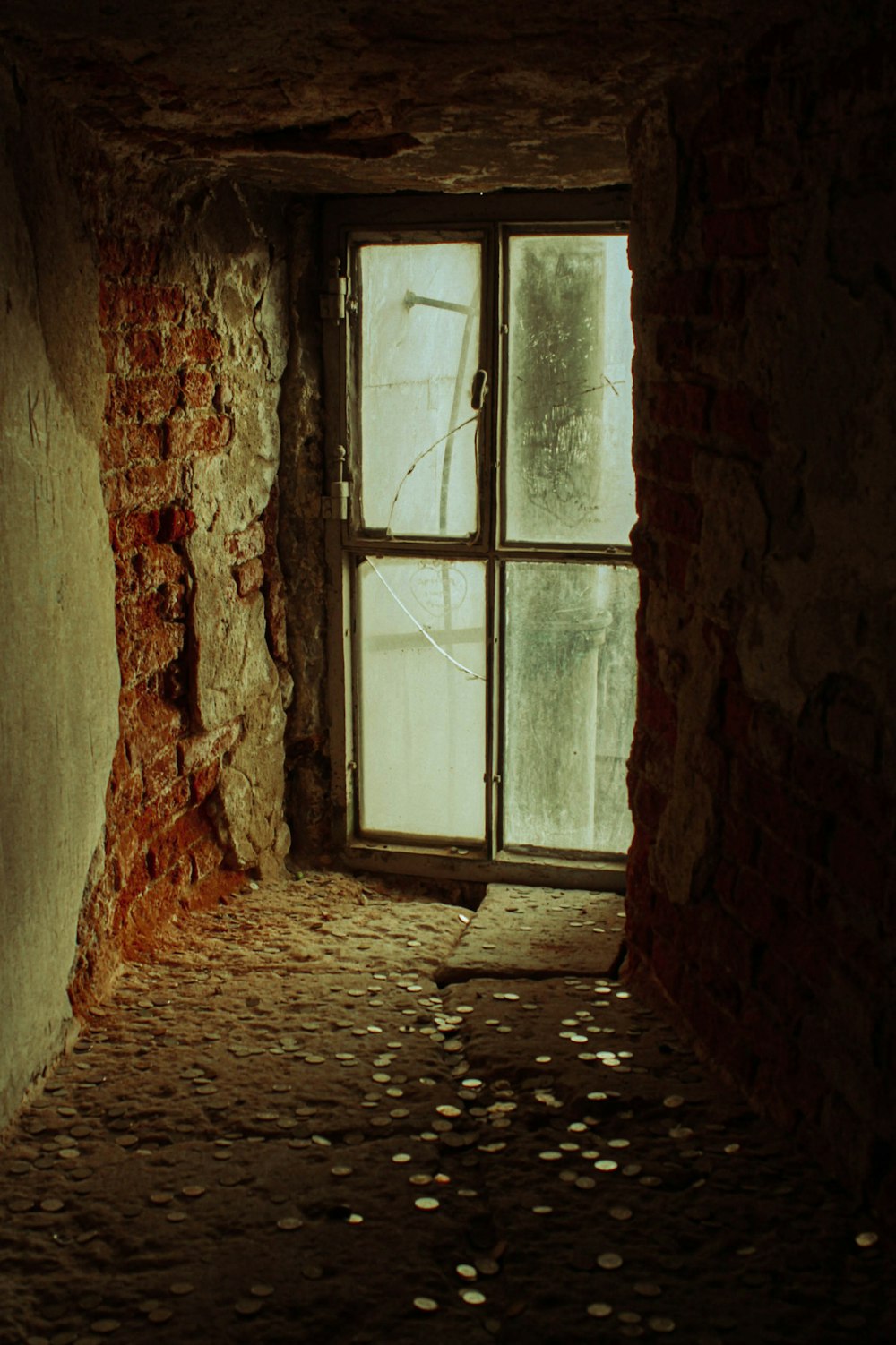 an empty room with a window and a brick wall