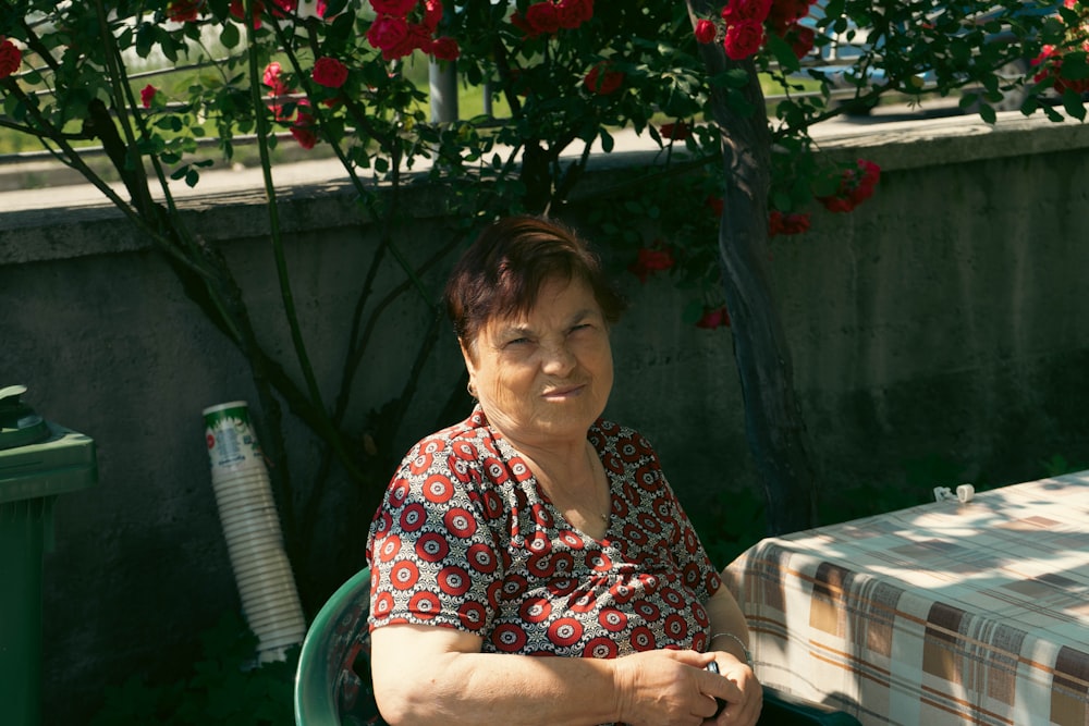 花の木を背景にテーブルに座っている女性