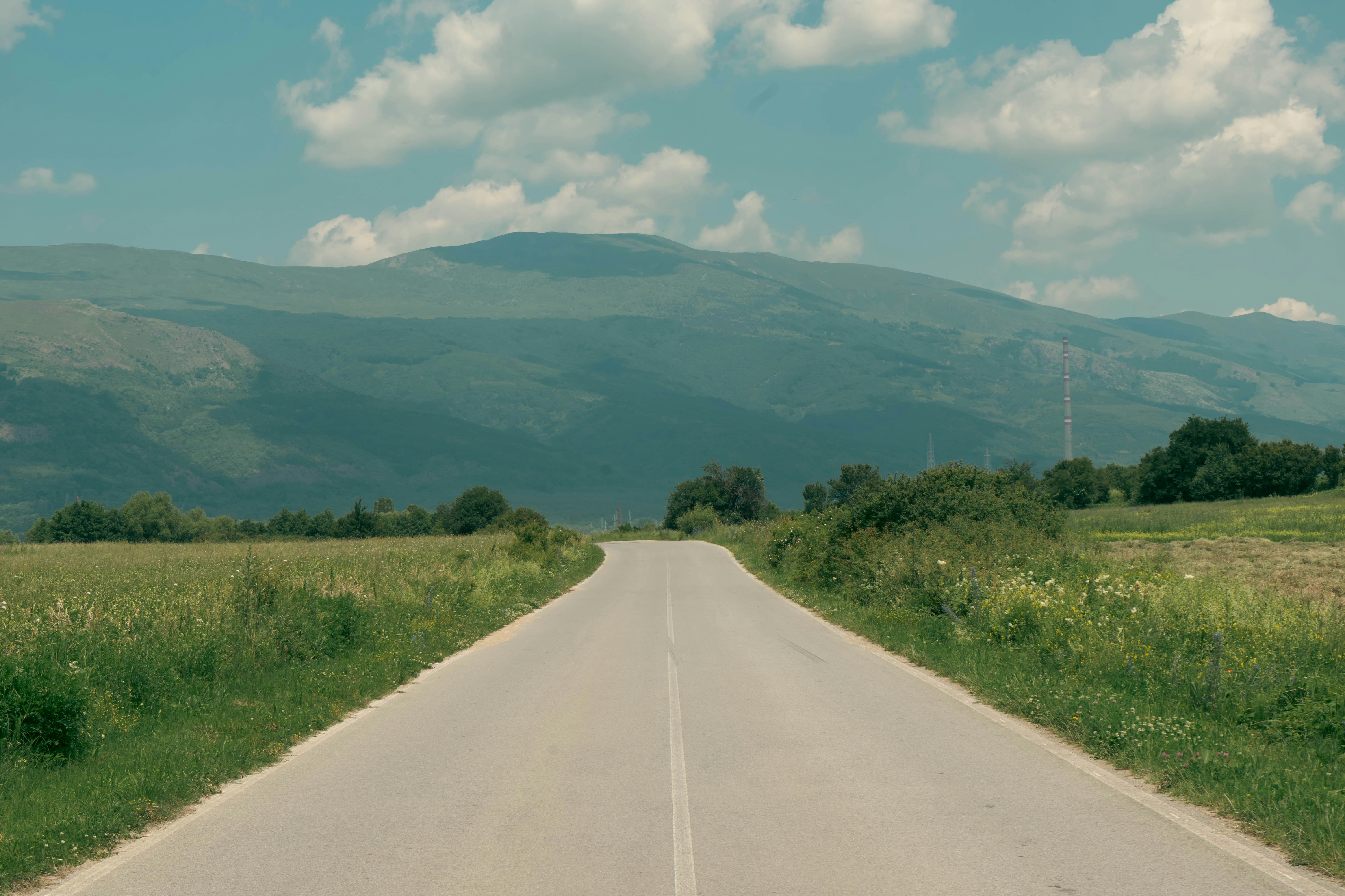 an empty road with a mountain in the background