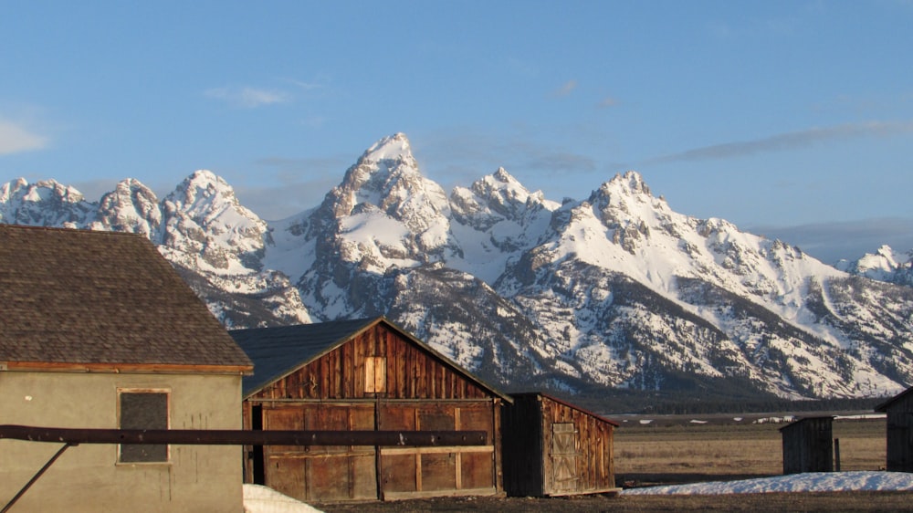 a barn sits in front of a mountain range