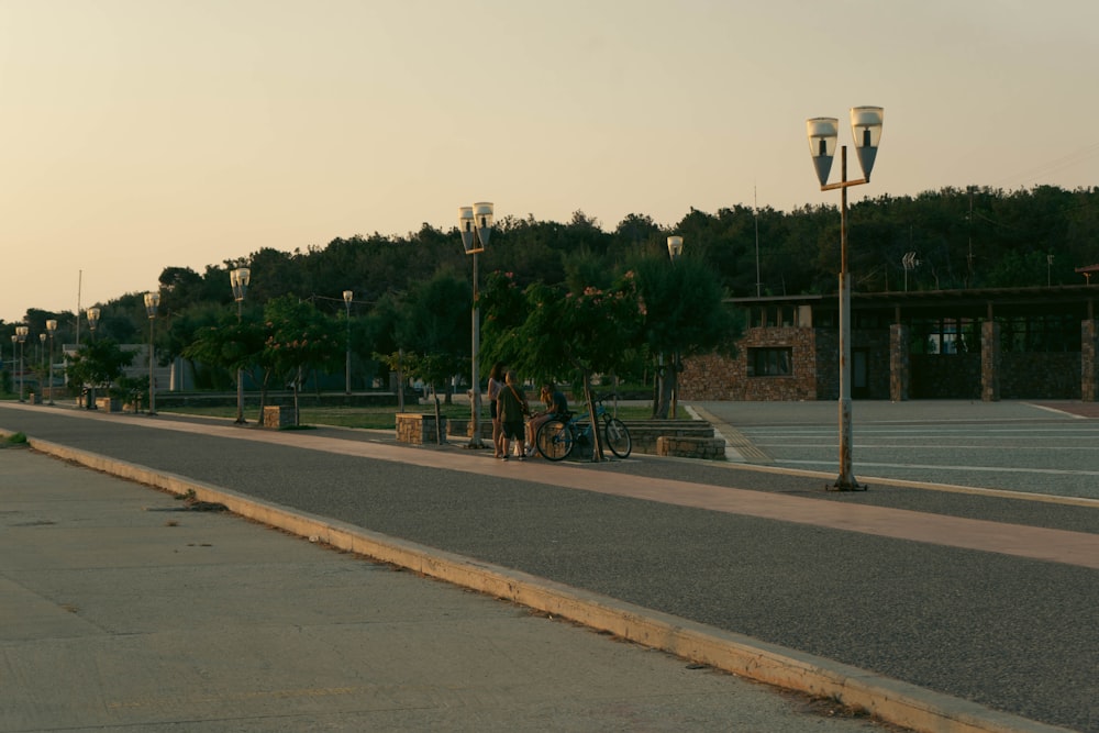 a group of people sitting on a bench next to a street