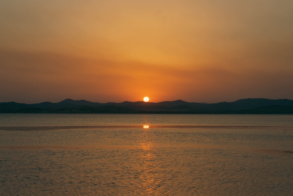 the sun is setting over a body of water