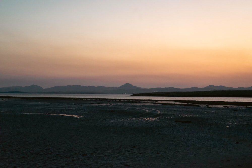 the sun is setting over a body of water