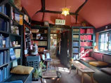 Bookshelves filled with teen novels featuring pink and floral designs in a cozy room
