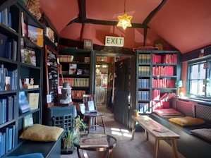 A warm, inviting room showcasing a variety of wooden bookshelves filled with books and decorative items.