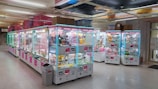 A colorful doll claw crane machine filled with plush toys in a bright arcade setting.