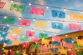 Close-up of artisanal Mexican sweets wrapped in bright papel picado, evoking festive street markets.