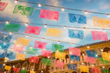 Wide-angle drone image capturing the colorful banners and active volunteers at Puente Valle de Puebla.