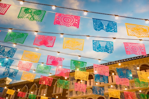 Colorful Mexican cultural symbols like papel picado and traditional foods.