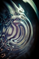 Abstract patterns created by swirling lights and reflections that appear fluid and dynamic, with an illusion of depth and movement.