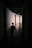 Two children holding light sticks run down a dimly lit hallway. Their silhouettes stand out against the brighter background.