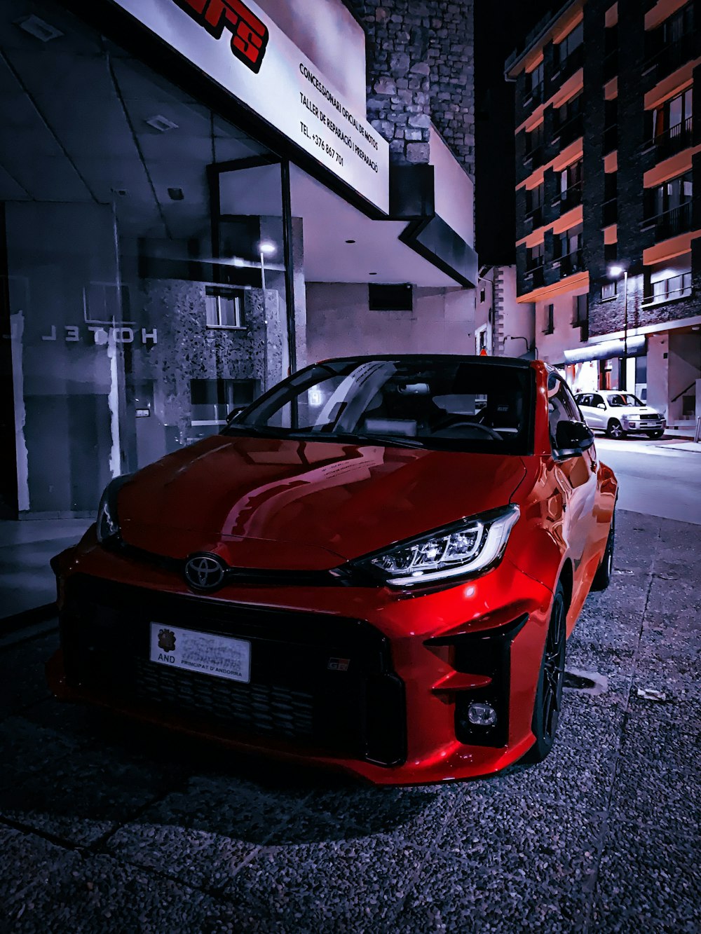 a red car parked in front of a building