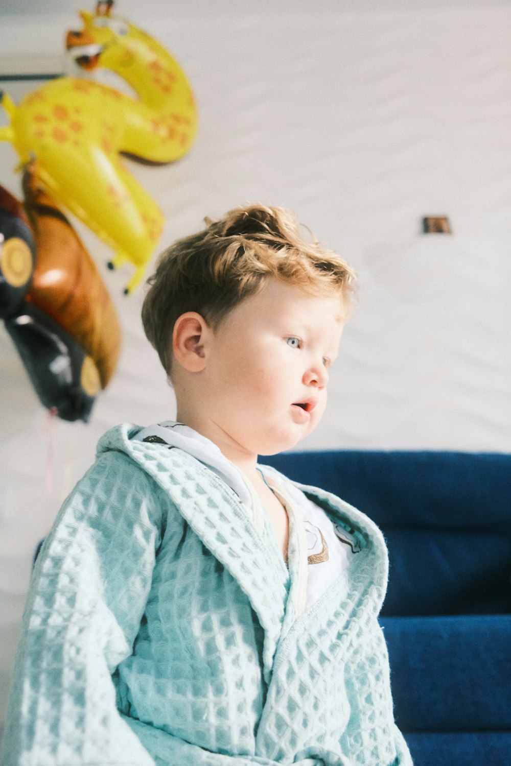 a young boy sitting on a blue couch