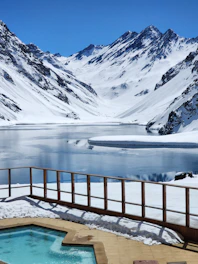 Modern cold plunge tub on a wooden deck overlooking a calm lake at sunrise.