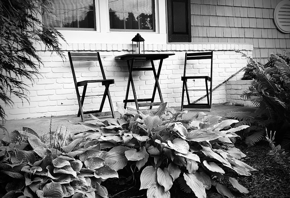 a black and white photo of two chairs and a table