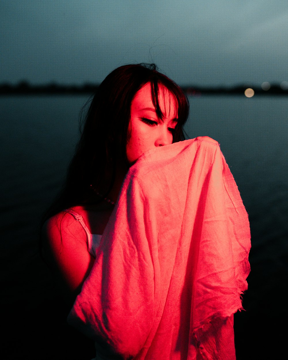 a woman in a pink shirt is standing by the water