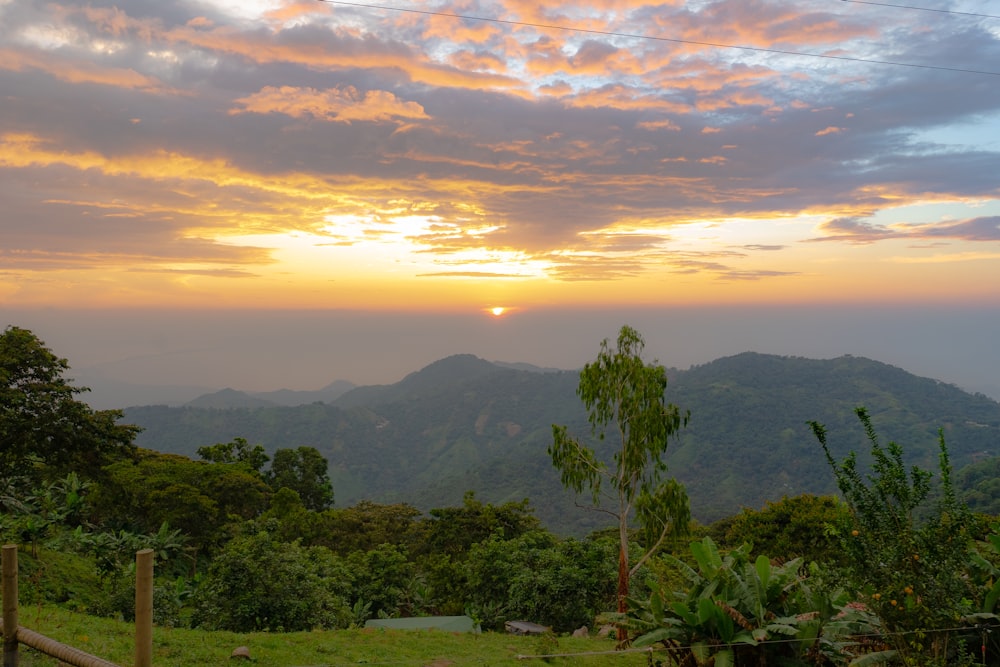 the sun is setting over the mountains in the distance