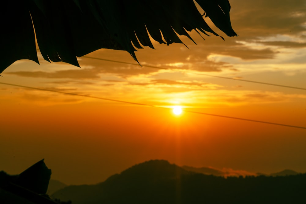 the sun is setting over a mountain range