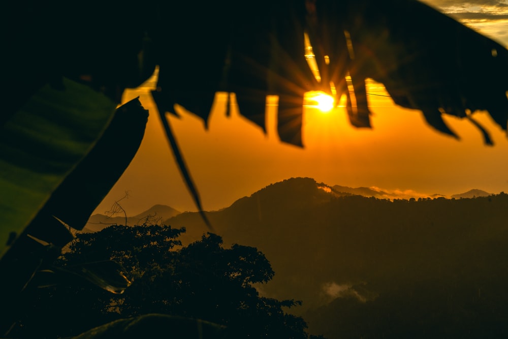 the sun is setting over a mountain range