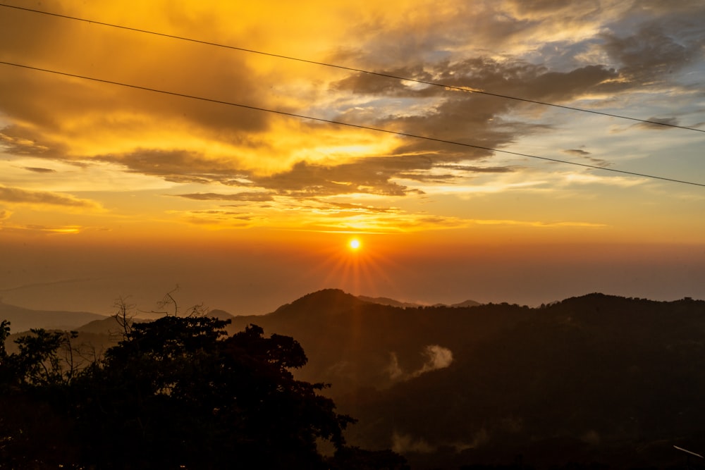 the sun is setting over a mountain range