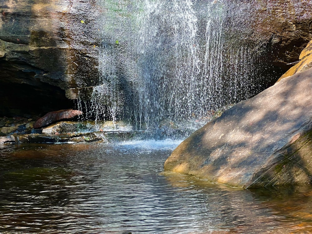 a waterfall is coming out of a cave