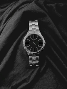 a watch sitting on top of a black cloth