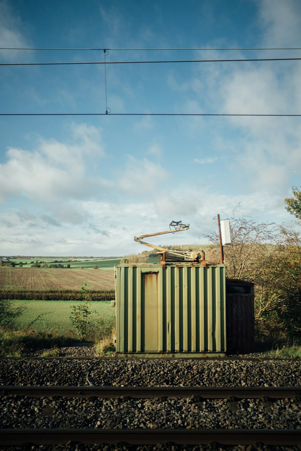 a green and white container sitting on train tracks