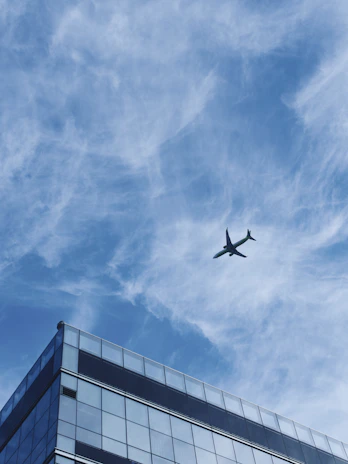 A panoramic view of a completed commercial building with glass facades reflecting the sky.