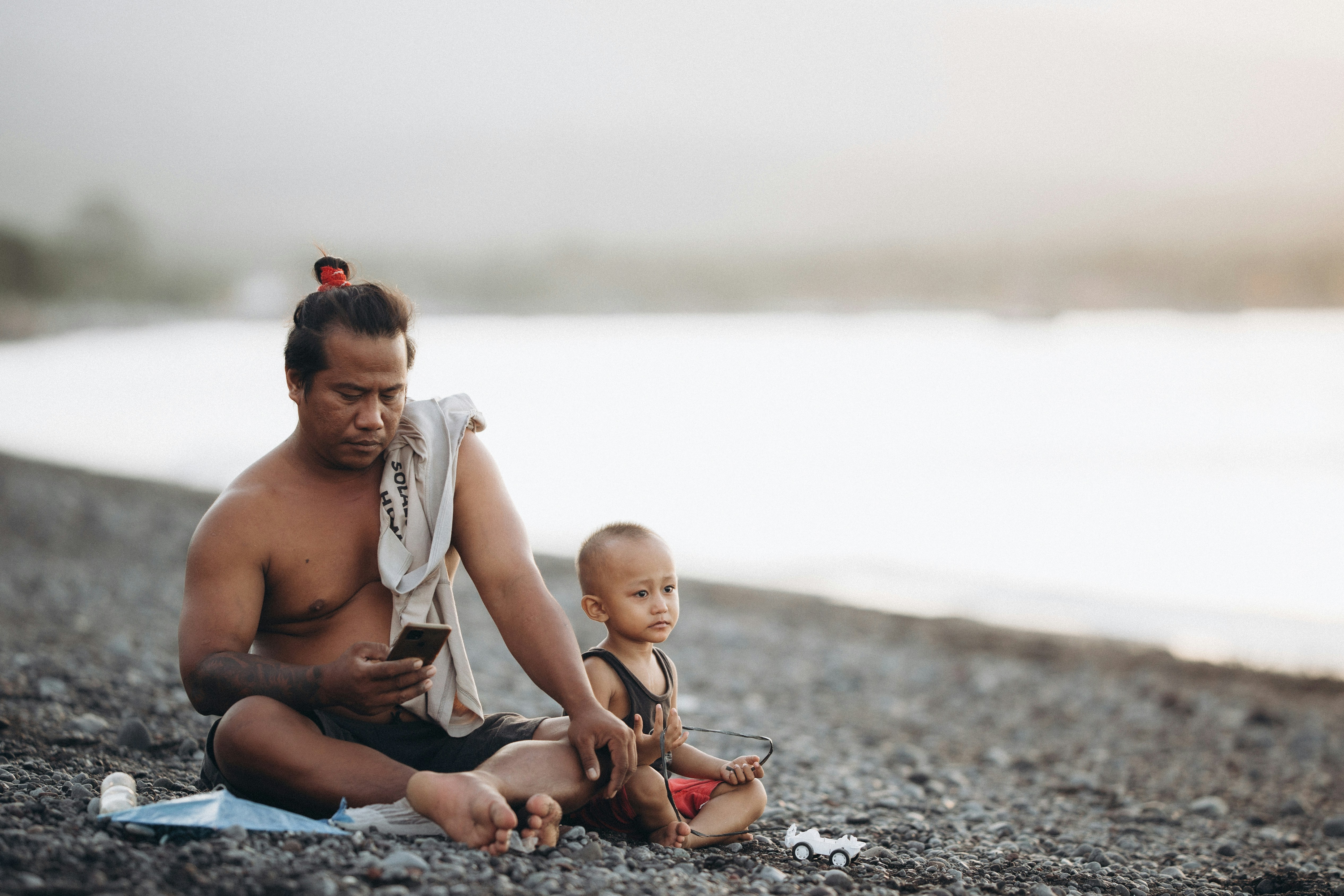 a man sitting on a beach next to a baby