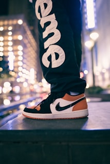 A nighttime shot of a person standing strong on graffiti-covered stairs wearing G Quake’s signature apparel.