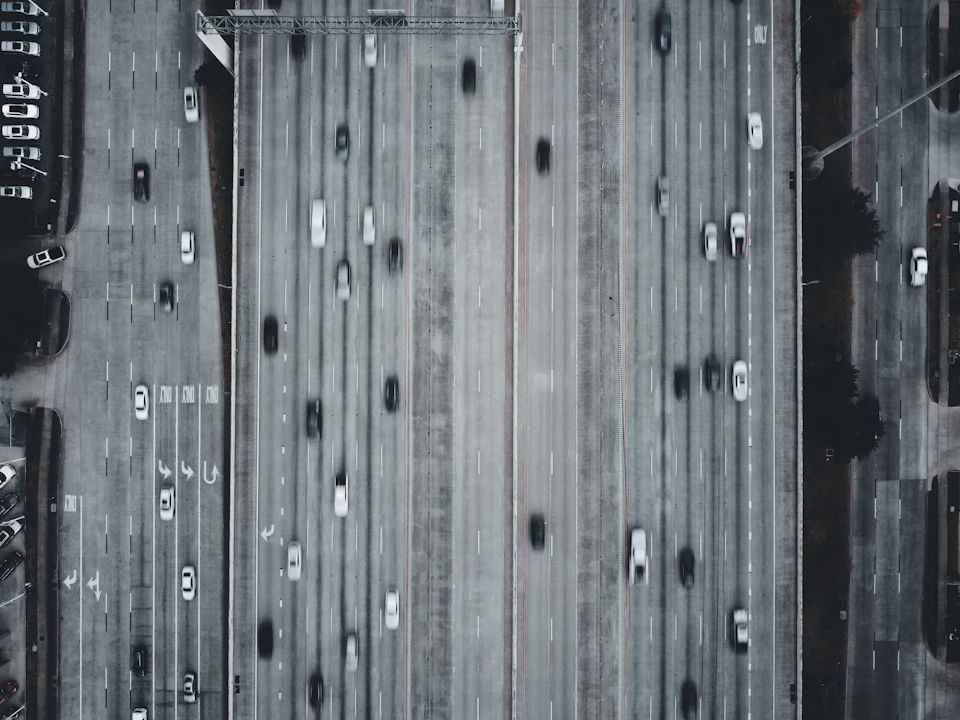 Busy highway with numerous cars moving in both directions under clear lane markings