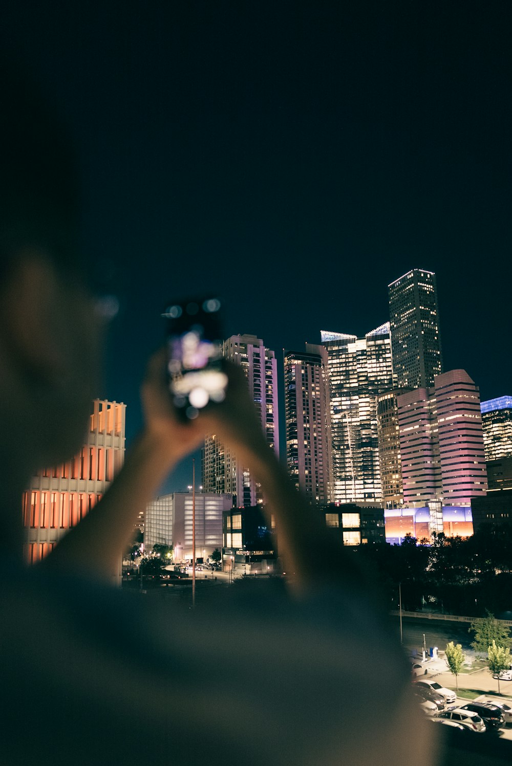 a man taking a picture of a city at night
