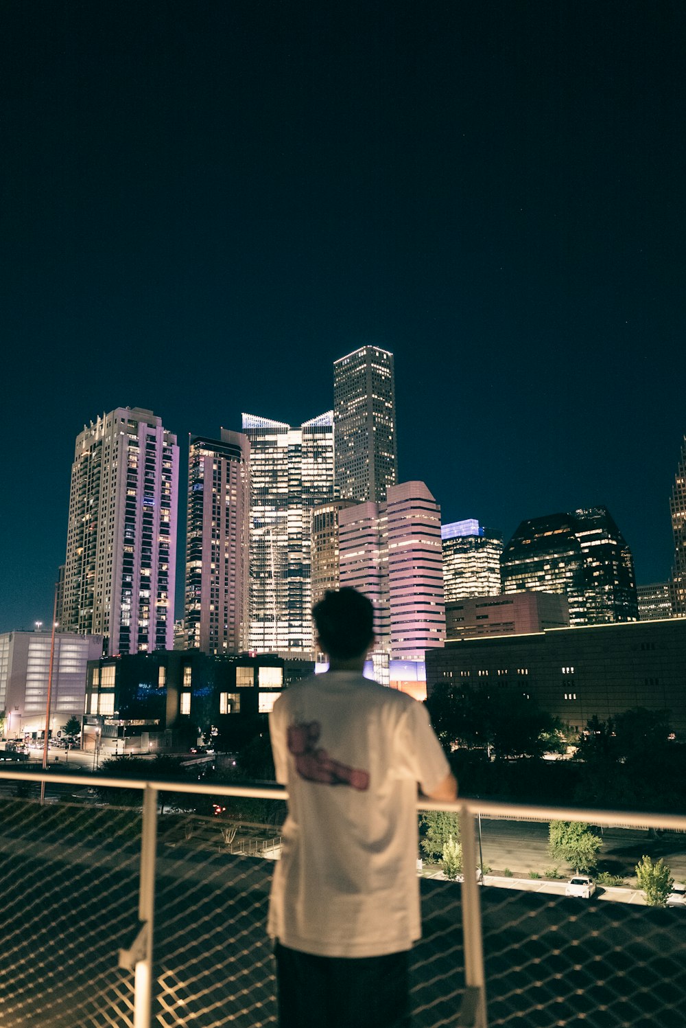 a man standing on a balcony looking at the city