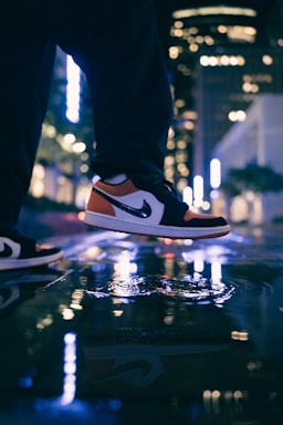 A man confidently walking in stylish sneakers on a city street.